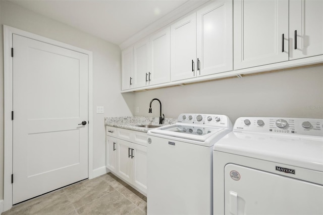 laundry area featuring cabinets, washing machine and dryer, light tile patterned floors, and sink