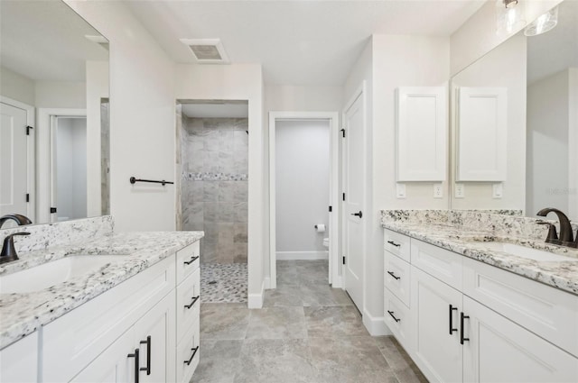 bathroom featuring vanity and tiled shower