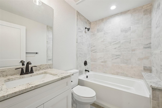 full bathroom featuring tiled shower / bath combo, toilet, and vanity