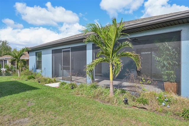 view of side of property with a sunroom and a yard