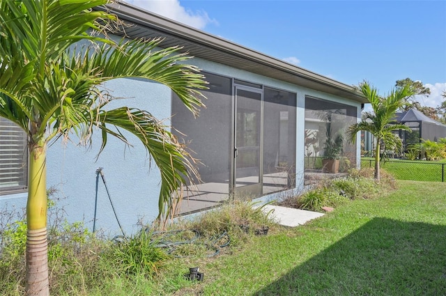 exterior space featuring a sunroom and a lawn