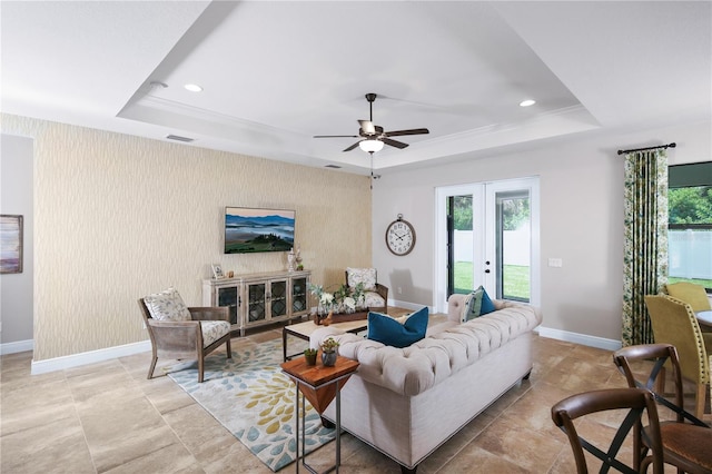 living room featuring french doors, ceiling fan, and a raised ceiling