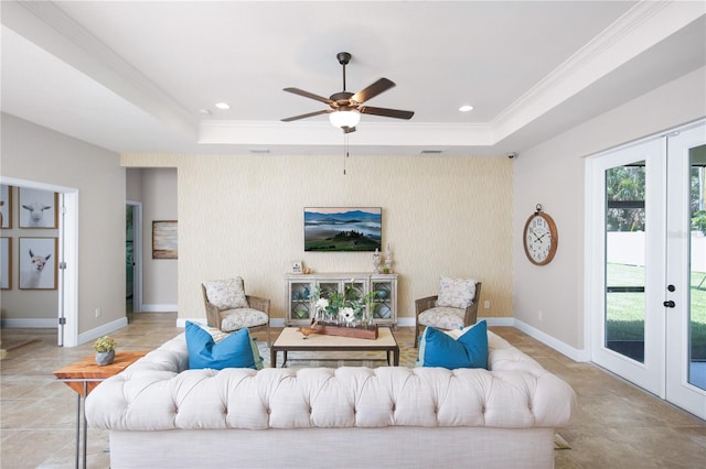 living room featuring ceiling fan, light tile patterned floors, a raised ceiling, ornamental molding, and french doors