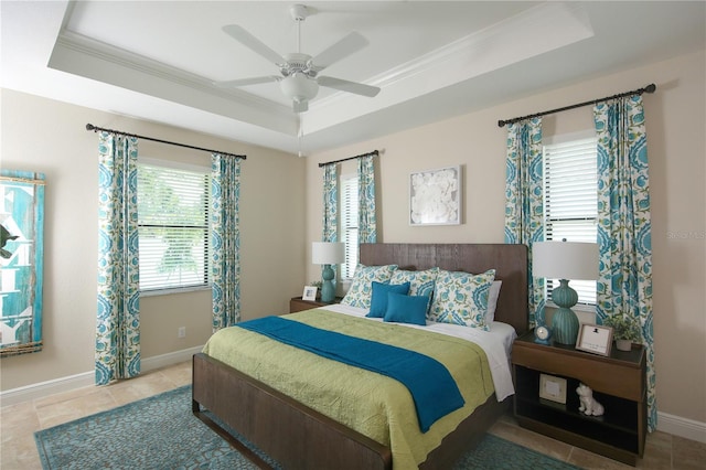 bedroom featuring ceiling fan, a raised ceiling, multiple windows, and crown molding