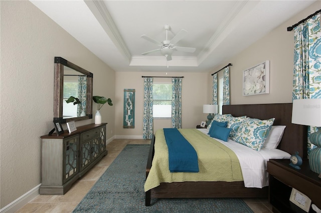 bedroom with ceiling fan, a raised ceiling, ornamental molding, and multiple windows