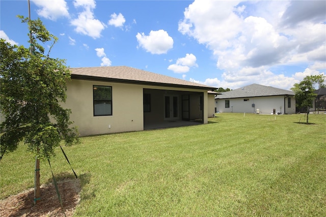 rear view of property with a yard