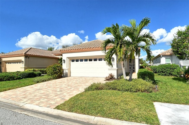 mediterranean / spanish house featuring a front yard and a garage