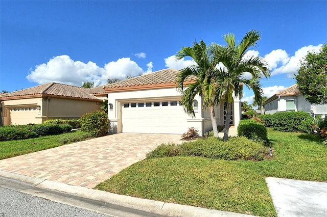 3924 Alamanda Dr, Sarasota, FL 34238 - mediterranean / spanish house with a tiled roof, an attached garage, decorative driveway, stucco siding, and a front lawn
