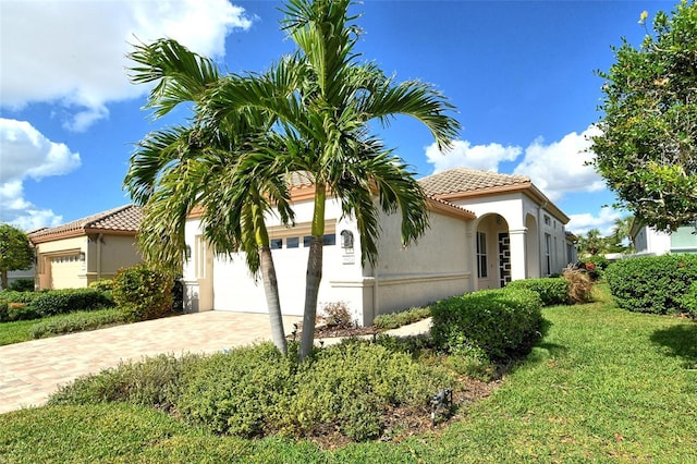 3924 Alamanda Dr, Sarasota, FL 34238 - view of front of property featuring a tile roof, decorative driveway, stucco siding, and a front lawn