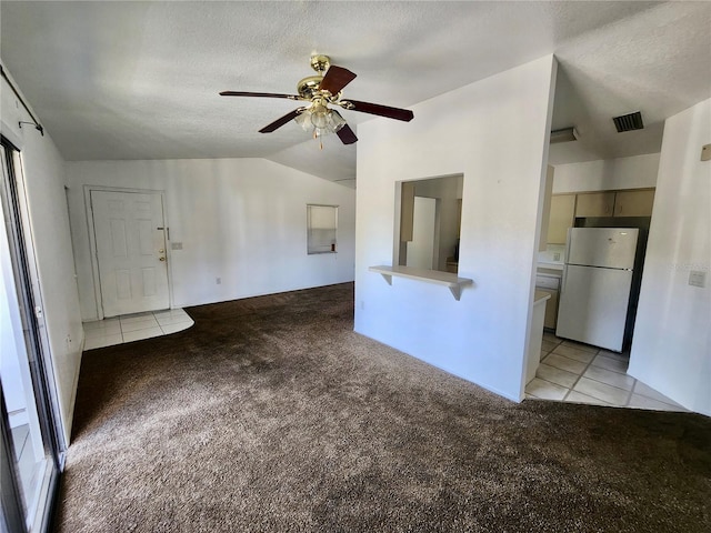 unfurnished living room featuring a textured ceiling, light colored carpet, and vaulted ceiling