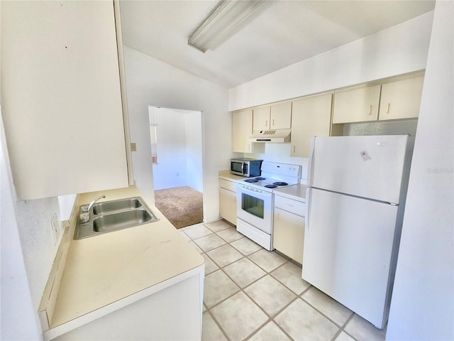 kitchen with lofted ceiling, cream cabinetry, sink, light tile patterned floors, and white appliances