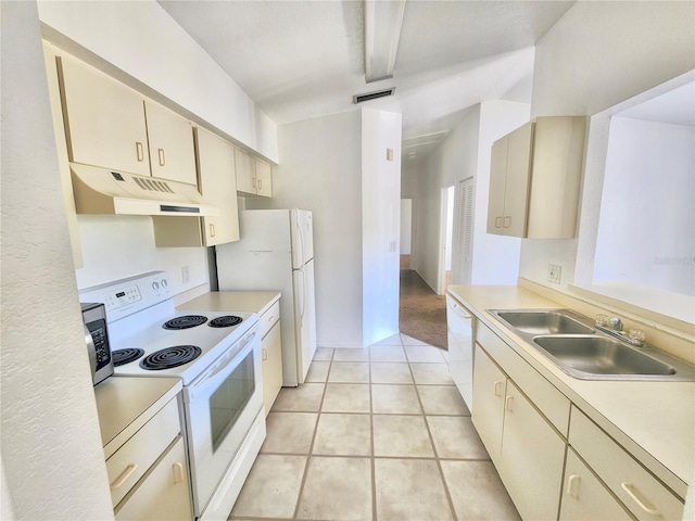 kitchen featuring cream cabinetry, sink, light tile patterned floors, and white appliances