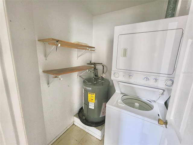 clothes washing area with light tile patterned floors, electric water heater, and stacked washer and dryer