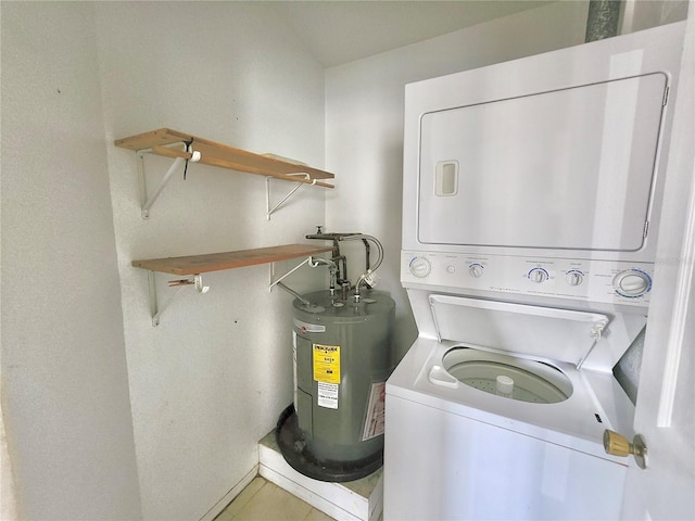 clothes washing area featuring water heater and stacked washer and clothes dryer