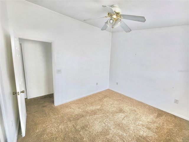 carpeted spare room featuring ceiling fan