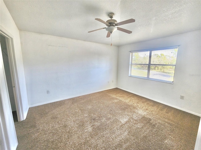 spare room with a textured ceiling, carpet flooring, and ceiling fan