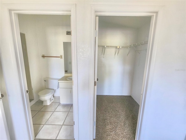 bathroom with toilet and tile patterned flooring