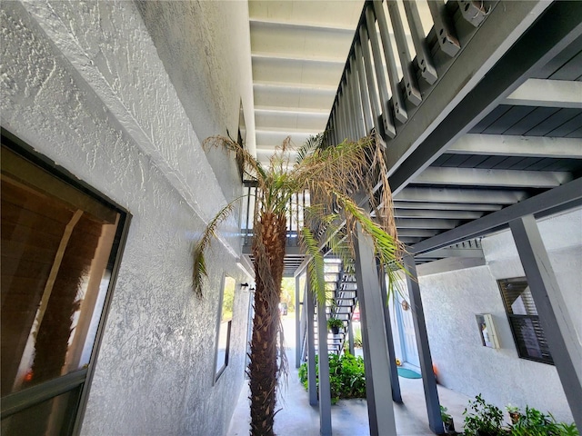 stairs featuring beamed ceiling