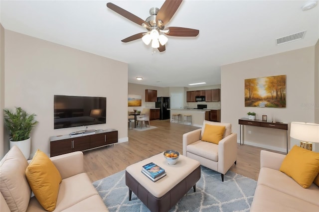 living room with light wood-type flooring and ceiling fan