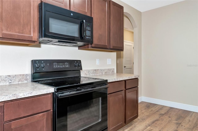 kitchen featuring light wood-type flooring and black appliances