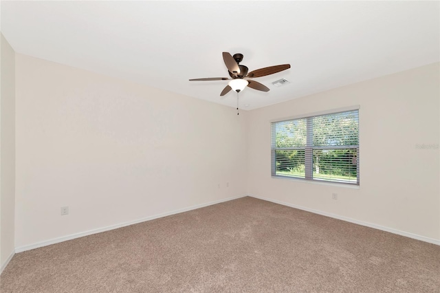 carpeted spare room featuring ceiling fan