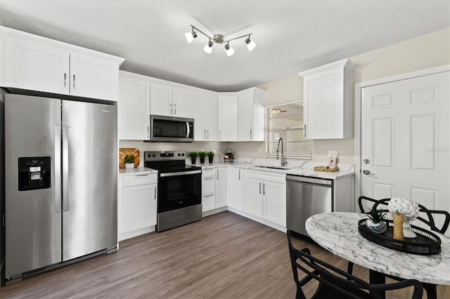 kitchen featuring sink, appliances with stainless steel finishes, dark wood-type flooring, and white cabinets