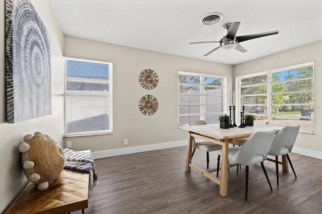 dining room featuring dark wood-type flooring, visible vents, a ceiling fan, and baseboards