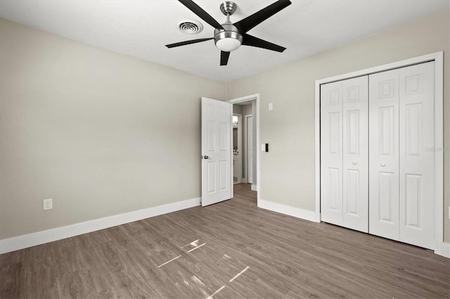 unfurnished bedroom with a closet, ceiling fan, and dark hardwood / wood-style flooring