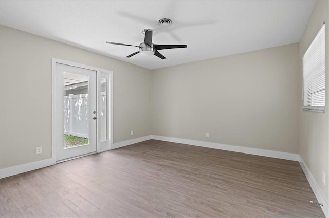 spare room featuring ceiling fan, hardwood / wood-style flooring, and plenty of natural light