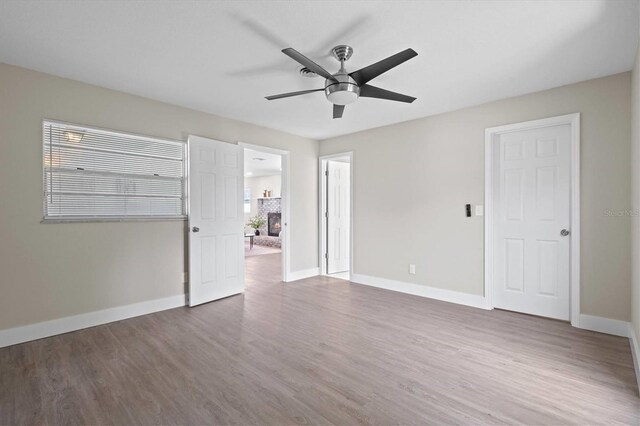 empty room with a healthy amount of sunlight, hardwood / wood-style flooring, and ceiling fan