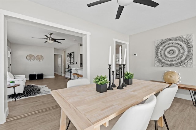 dining room featuring lofted ceiling, hardwood / wood-style flooring, and ceiling fan