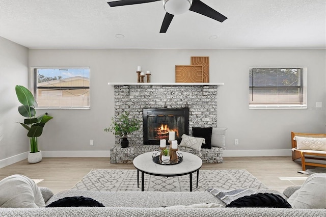 living room featuring light hardwood / wood-style floors, a textured ceiling, and ceiling fan