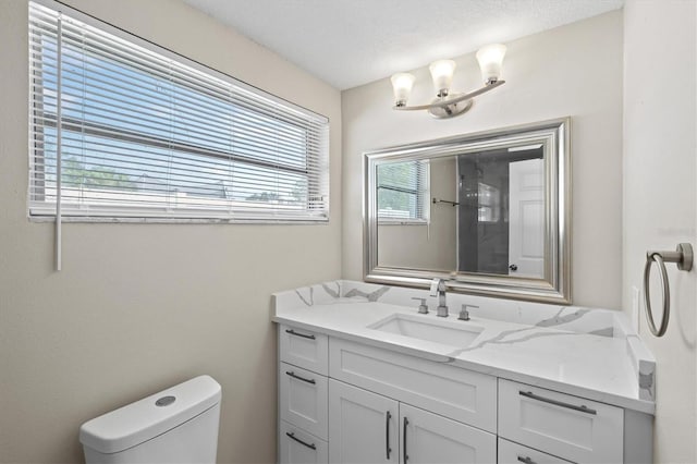 bathroom featuring vanity, a textured ceiling, and toilet