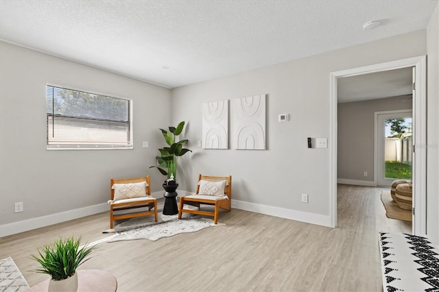 sitting room featuring light hardwood / wood-style flooring and a textured ceiling