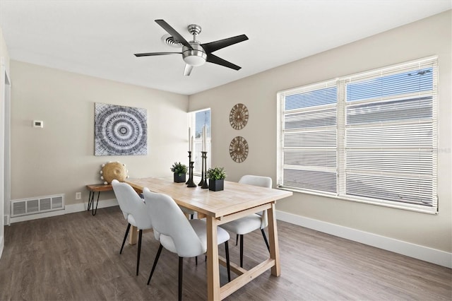 dining space with visible vents, baseboards, a ceiling fan, and wood finished floors