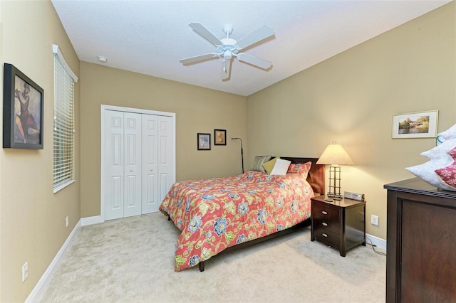 bedroom featuring light colored carpet, a closet, and ceiling fan