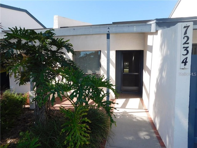 entrance to property featuring stucco siding