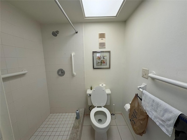 bathroom with a tile shower and toilet