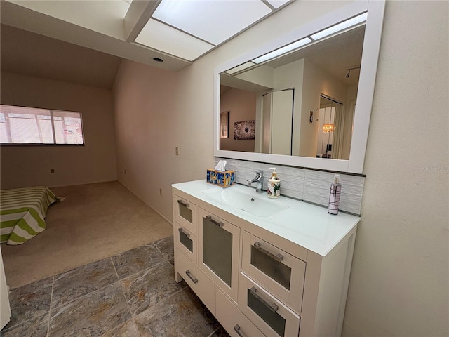 bathroom featuring backsplash, vanity, and stone finish floor