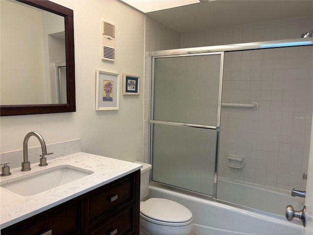 bathroom with vanity, toilet, visible vents, and enclosed tub / shower combo