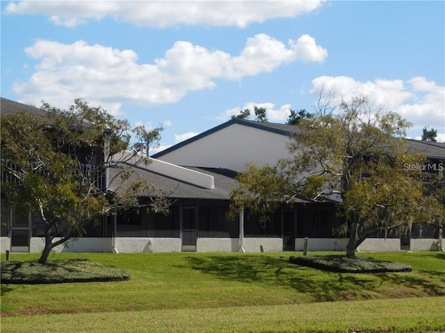 view of front of property with a front yard and a sunroom