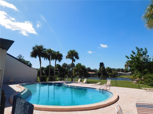 community pool with a yard, a patio, and fence