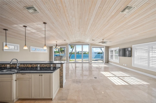 kitchen with ceiling fan with notable chandelier, decorative light fixtures, dark stone counters, sink, and wooden ceiling