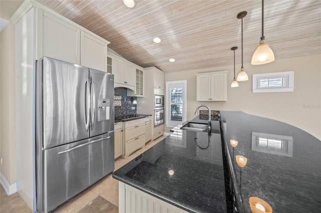 kitchen with appliances with stainless steel finishes, decorative light fixtures, white cabinetry, sink, and backsplash