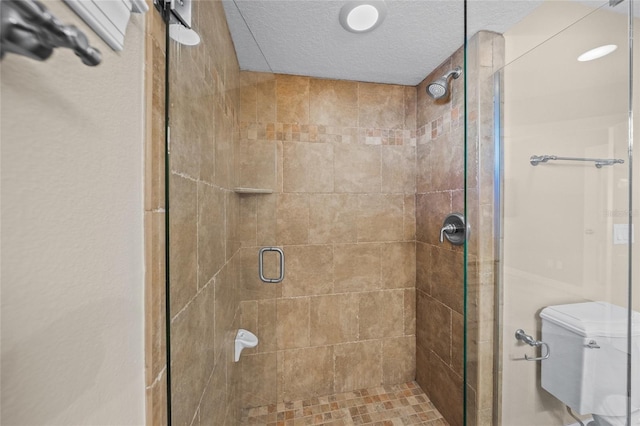 bathroom with toilet, a shower with door, and a textured ceiling