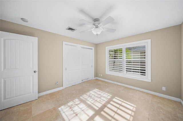 unfurnished bedroom with ceiling fan and a closet