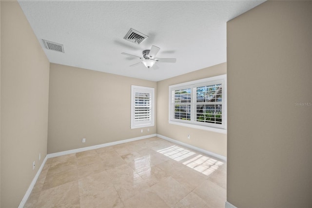 spare room featuring a textured ceiling and ceiling fan