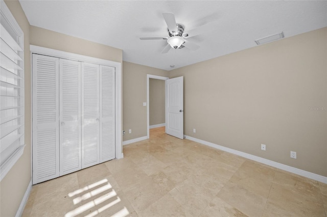 unfurnished bedroom with ceiling fan and a closet