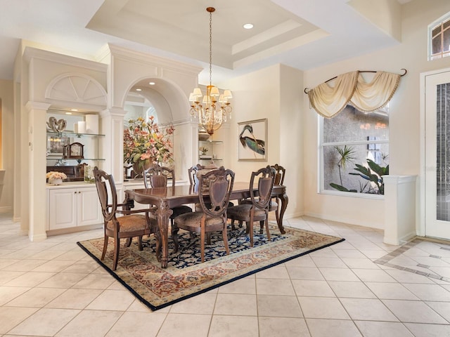 dining space featuring light tile patterned flooring, a notable chandelier, and a raised ceiling