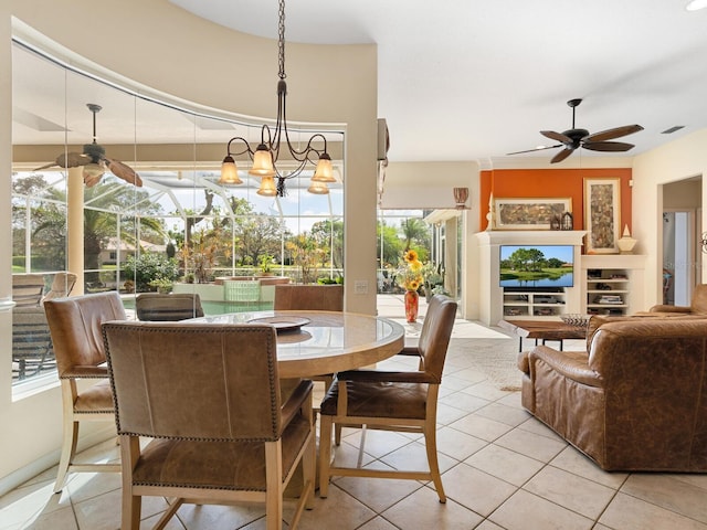 dining space featuring ceiling fan with notable chandelier and light tile patterned floors